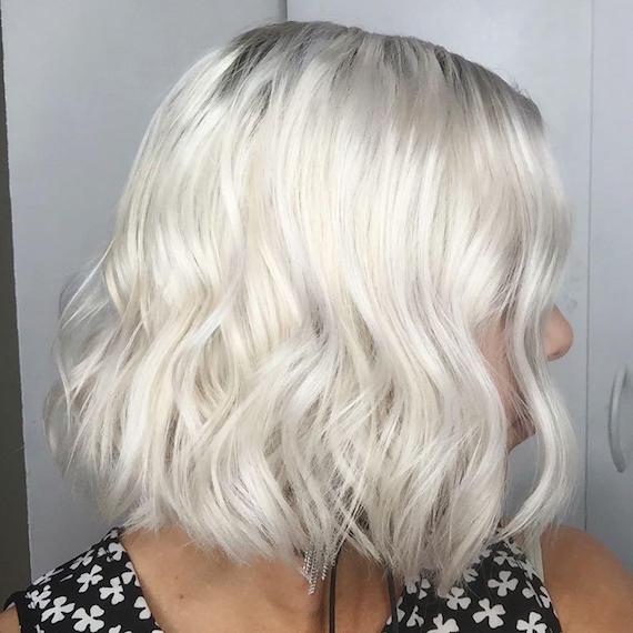 Side-on image of woman with ice blonde, wavy bob, created using Wella Professionals