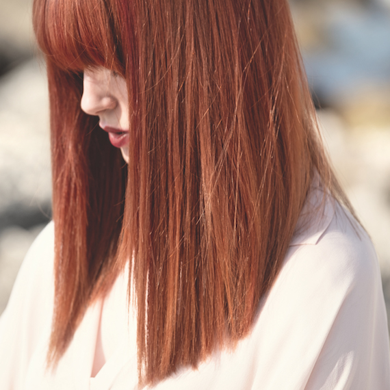 YouTuber Melanie Murphy with long, straight hair wearing Wella Professionals Leather Red hair color