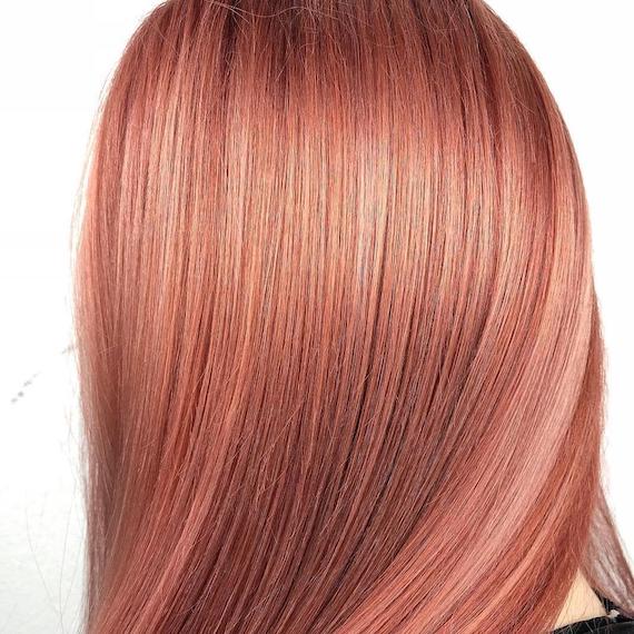 Back of woman’s head showing straight, sleek, peach hair, created using Wella Professionals