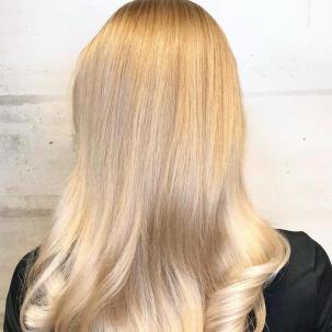 Back of woman’s head with shiny blonde hair after a Wella Pure Glossing Service.