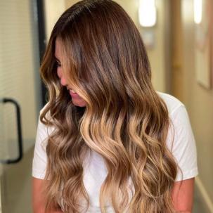 Side profile of woman with long, wavy brown hair and a blonde dip-dye, created using Wella Professionals.