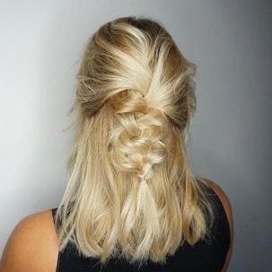 Model with blonde hair wearing a loose half-up braid, created using Wella Professionals