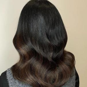 Back of woman’s head with dark espresso hair and chocolate balayage.