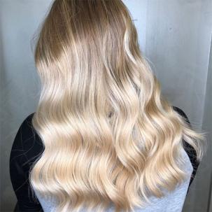Woman with cool-toned long blonde hair, styled with loose waves