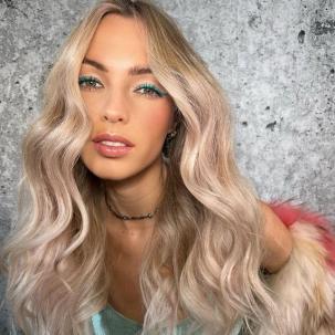 Model with long, vanilla blonde hair styled in beachy waves.