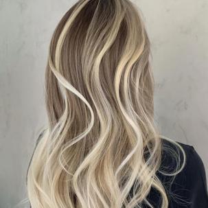 Back of woman’s head with chunky, platinum blonde highlights through long, wavy hair.