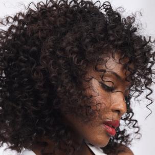 Side profile of a model with dark brown curly hair wearing red lipstick