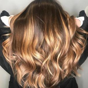 Warme blonde Highlights auf braunem Haar, kreiert mit Wella Professionals.