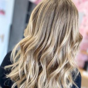 Hinterkopf einer Frau mit lockigem, mittellangem beige-blondem Haar, kreiert mit Wella Professionals.