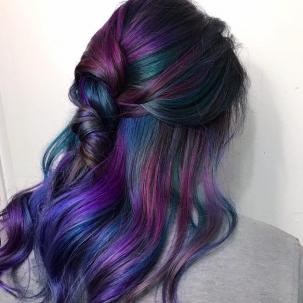 Woman with rainbow hair, half up half down hair styled with loose waves