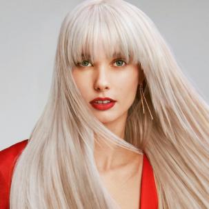 Model with long, straight, platinum blonde hair and bangs looks directly at the camera.