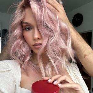 Model with loosely curled, platinum pink hair. 