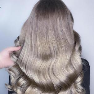 Back of woman’s head with long, loosely curled mushroom blonde hair, created using Wella Professionals.