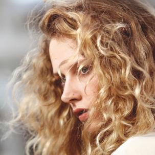 Model with blonde wavy hair blowing in the wind, created using Wella Professionals