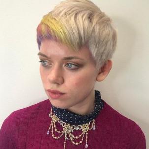 Woman with short ice blonde hair with rainbow fringe