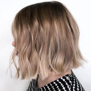 Side profile of woman with tousled ombre bob haircut.