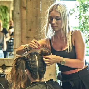 Hairstylist doing plaits on a client