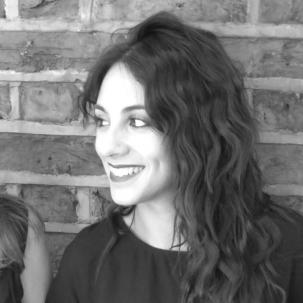 Woman with dark wavy hair in black and white