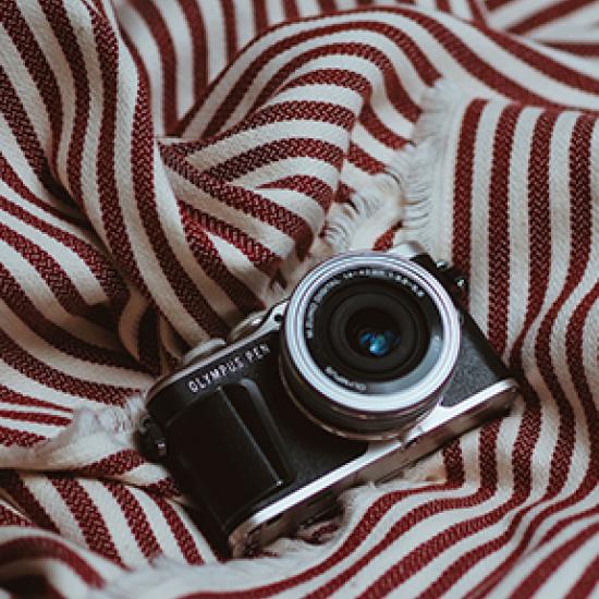 Camera on red and cream striped throw