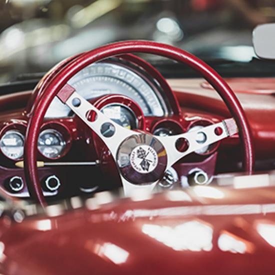 close up of burgundy car wheel and dashboard 