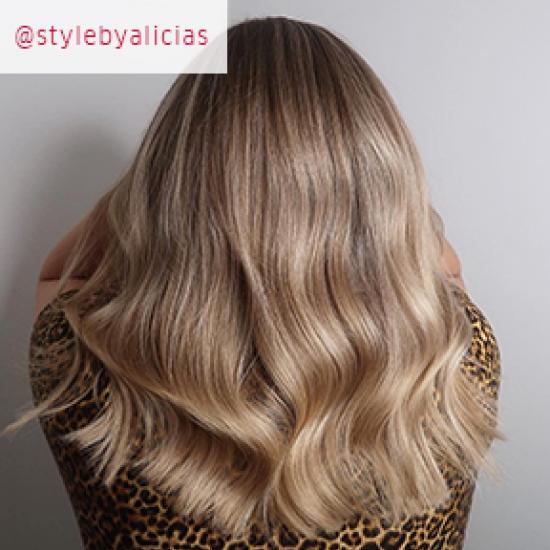 Photo of the back of a woman’s head with long, wavy, Powdered blonde hair, created using Wella Professionals.