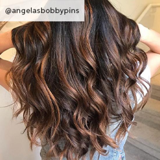 back of woman’s head with chestnut brown hair and caramel highlights