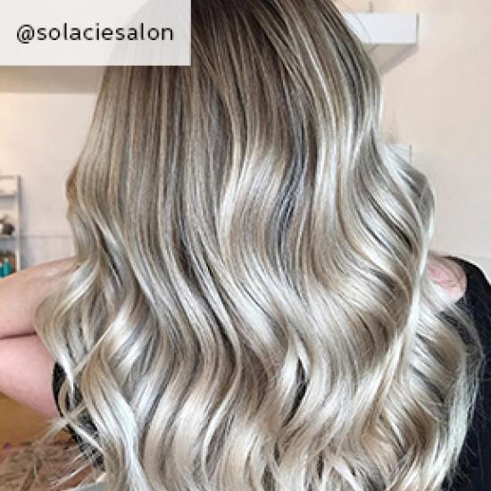 Back of woman’s head with long, wavy, dark ash blonde hair, created using Wella Pro-fessionals.