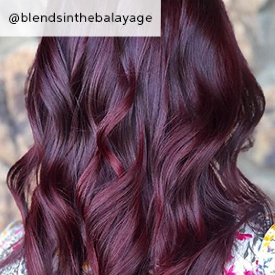 Back of woman’s head with loosely tousled, dark purple hair, created using Wella Professionals. 