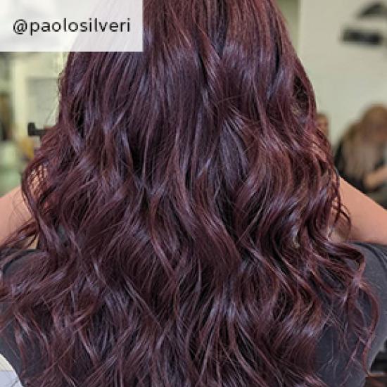 Back of woman’s head with long, wavy, dark purple hair, created using Wella Professionals. 