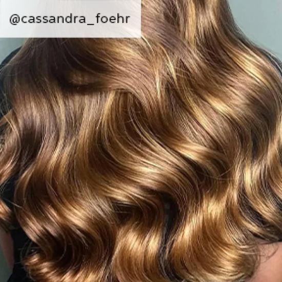 Back of woman’s head with golden brown, wavy hair, created using Wella Professionals.
