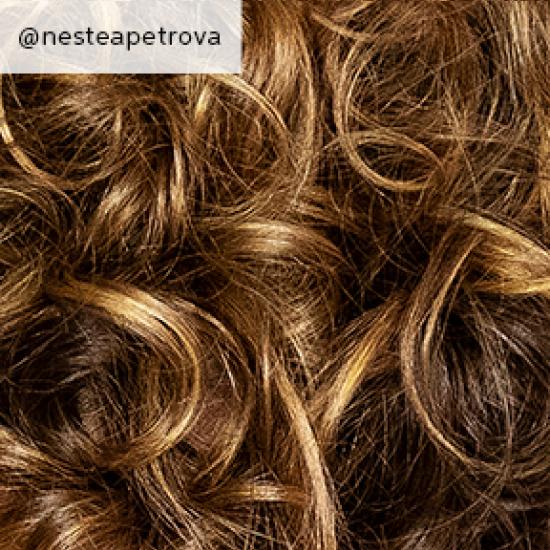 Close-up of golden brown, curly hair, created using Wella Professionals.
