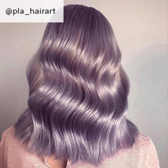 Back of woman’s head with mid-length, wavy, lilac hair, created using Wella Professionals.