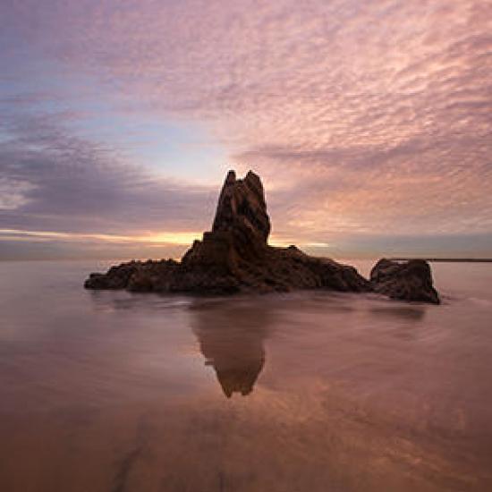 large rock under cloudy pink sky