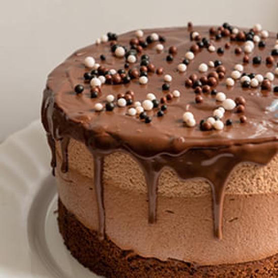 Chocolate cake with beige icing dripping down the sides