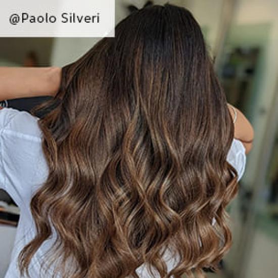 Model with wavy hair using Signature Naturals Collection product facing away by @Paolo Silveri