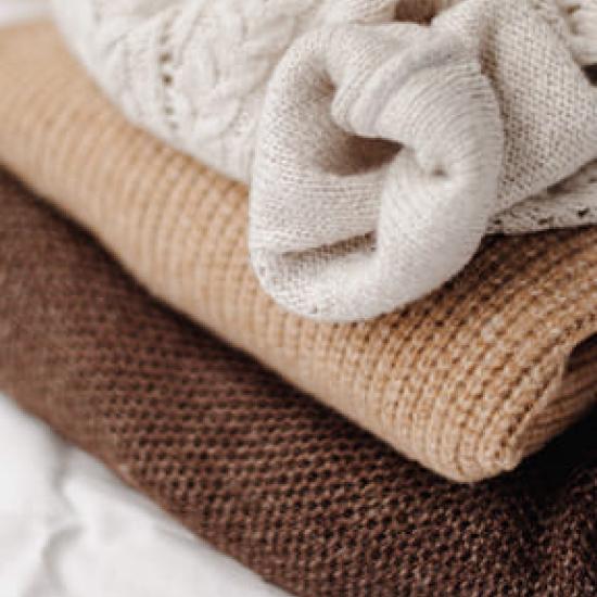Beige wool cardigans folded and stacked on top of each other