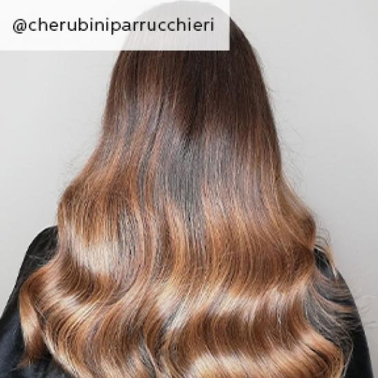 Back of woman’s head with long, wavy, light brown sombre hair, created using Wella Professionals.