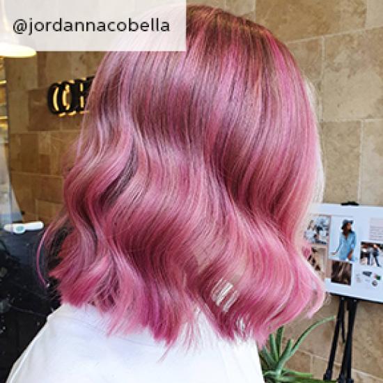 The side of a woman's pink pastel tone hair with soft curls