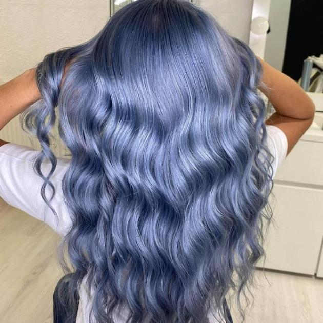 Back of woman’s head with long, loosely curled, metallic blue hair, created using Wella Professionals.
