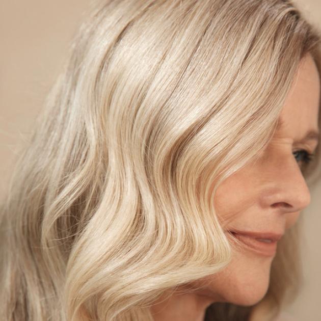 Side profile of model with vanilla blonde hair styled in soft waves.