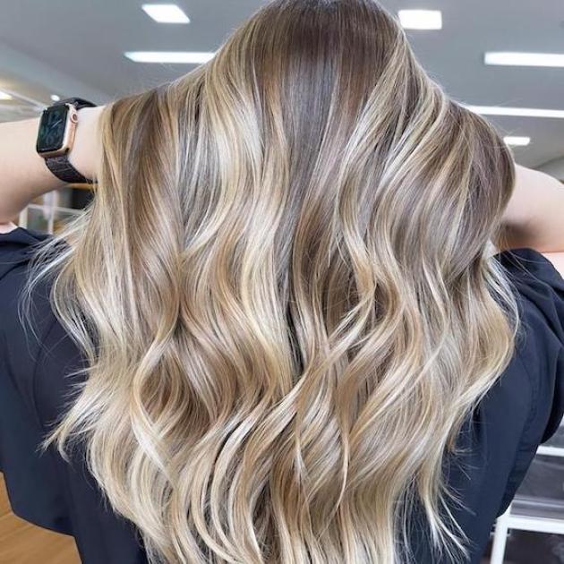 Back of woman’s head with long, wavy, beachy blonde hair.