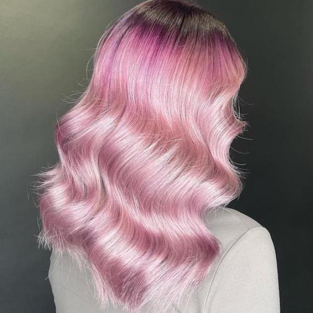 Back of woman’s head with long, wavy, pink hair, created using Wella Professionals.