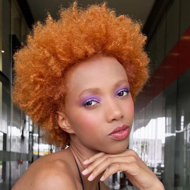 Model with type 4C curly hair faces camera. 