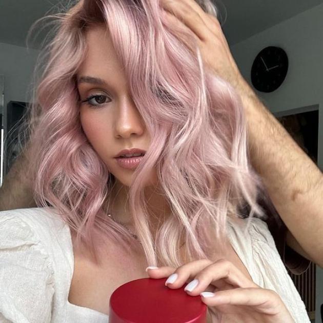 Model with loosely curled, platinum pink hair. 