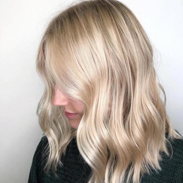 Side profile of model with wavy, blonde, mid-length hair, created using Wella Professionals.