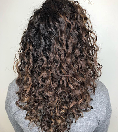 Curly ash brown balayage, created using Wella Professionals