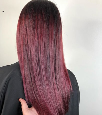 Woman with long, straight plum hair created with Wella Professionals