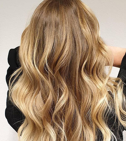 Bild von welligem Buttertoffee-blondem Haar, kreiert mit Wella Professionals