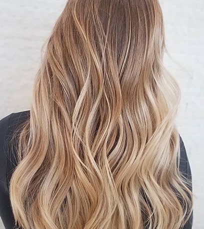 Photo of the back of a woman’s head with subtle blonde balayage, created using Wella Professionals.