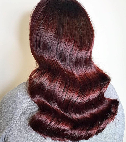 Wavy, elegant cherry cola hair colour, created using Wella Professionals products